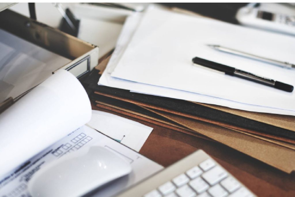 Uma imagem de vários papéis e caneta, ilustrando tradução juramentada diploma