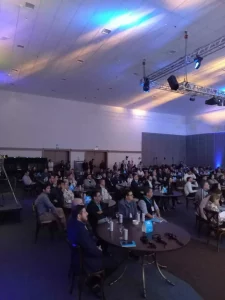 VĂĄrias pessoas sentadas assistindo a conferĂȘncia Ball Brasil 2022