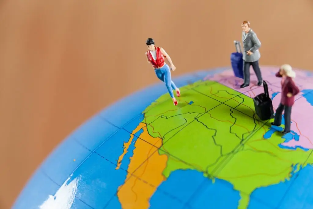 Miniaturas de pessoas viajando pelo globo, representando os países mais seguros do mundo