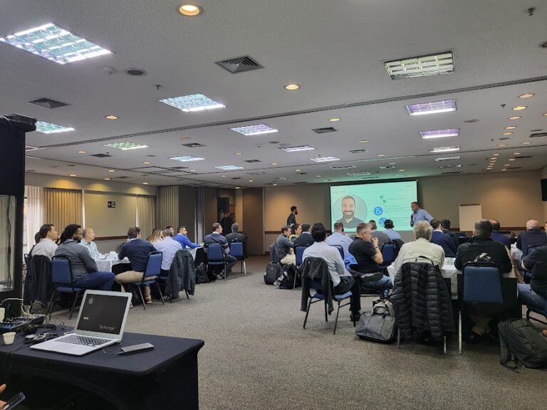 grupos de colaboradores da Tecflux assistindo à apresentação de entrada do treinamento de vendas