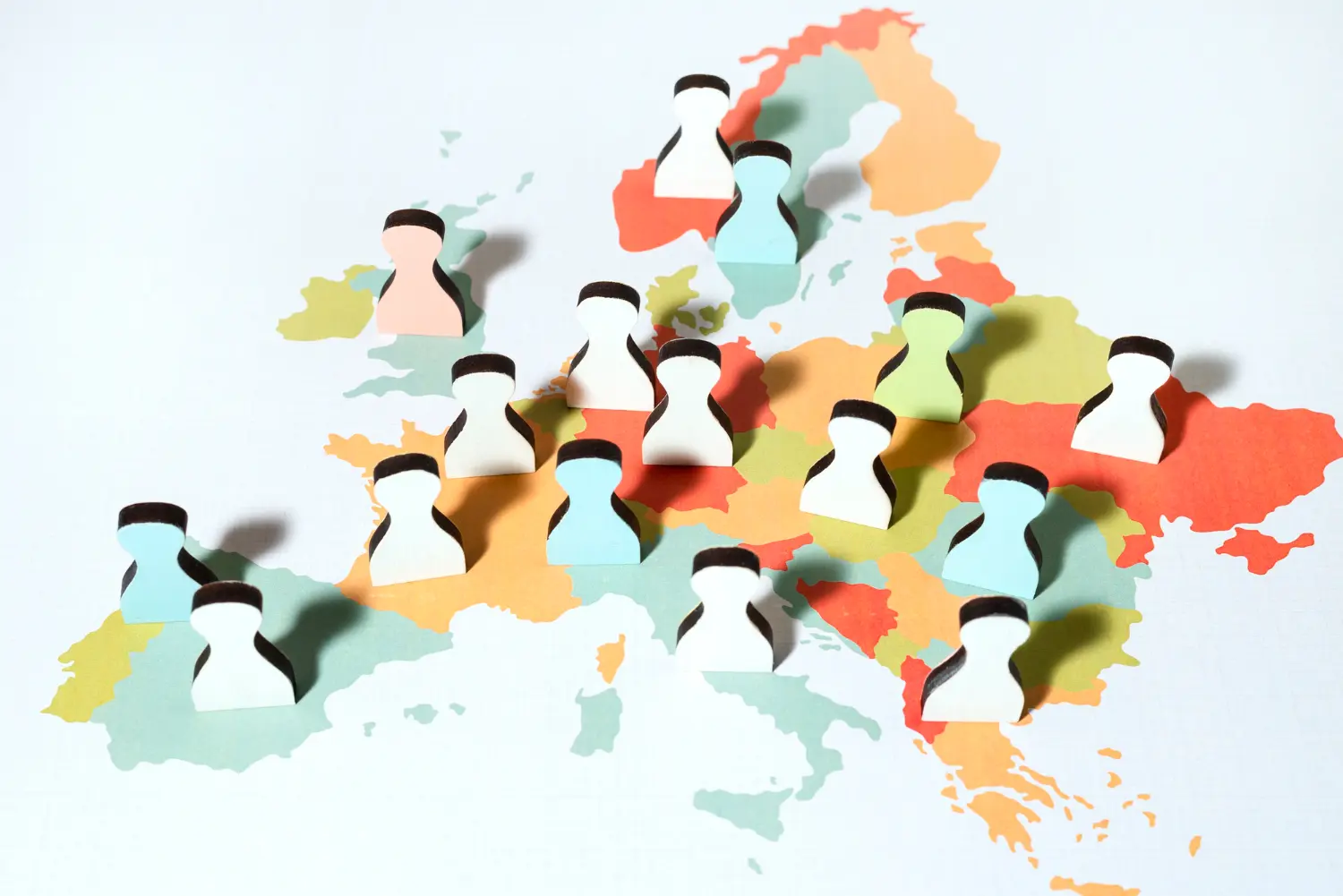 Vários bonecos coloridos sobre um mapa-múndi, representando a diversidade de nacionalidade e cidadania.