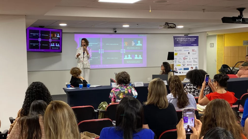 pessoa escutando atentamente uma apresentação no congresso nacional de tributação e gênero