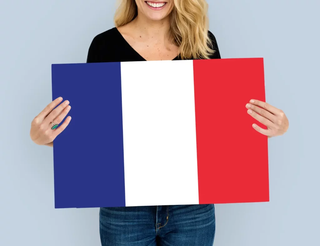 Mulher branca estudante que recebe os benefícios da CAF segurando a bandeira da França.