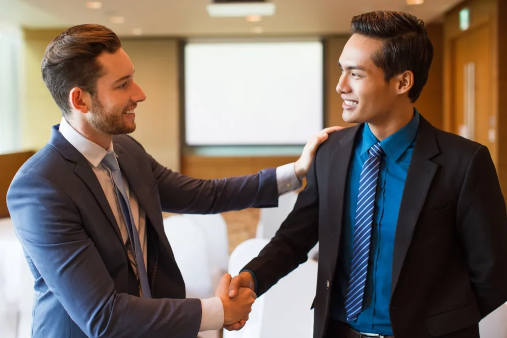 Empresários apertando as mãos após o sucesso dos negócios em razão de bons serviços de tradução para empresas