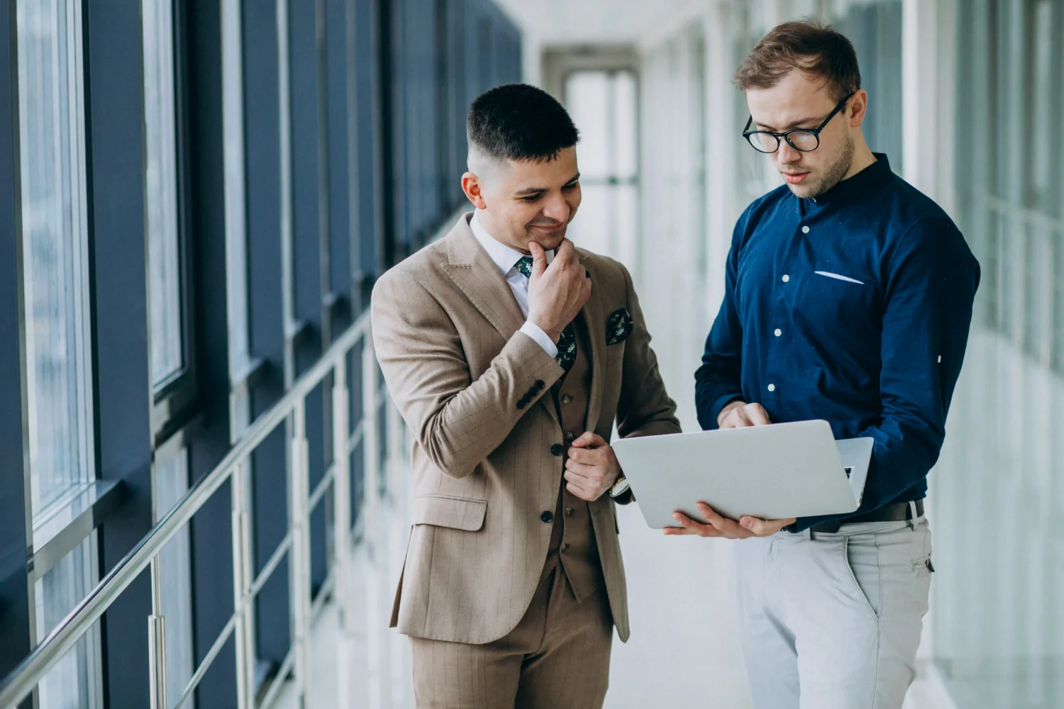 Dois empresários em pé segurando um notebook