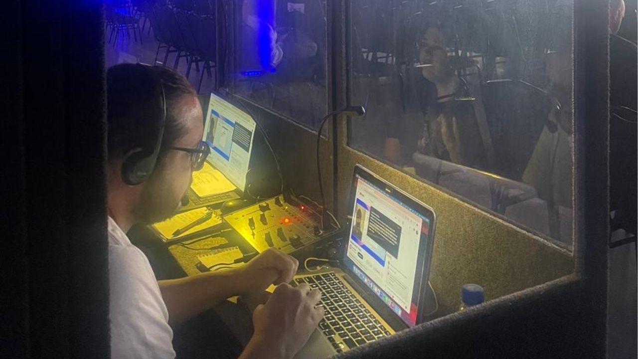 duas pessoas realizando a tradução simultânea do evento Ripio Brasil
